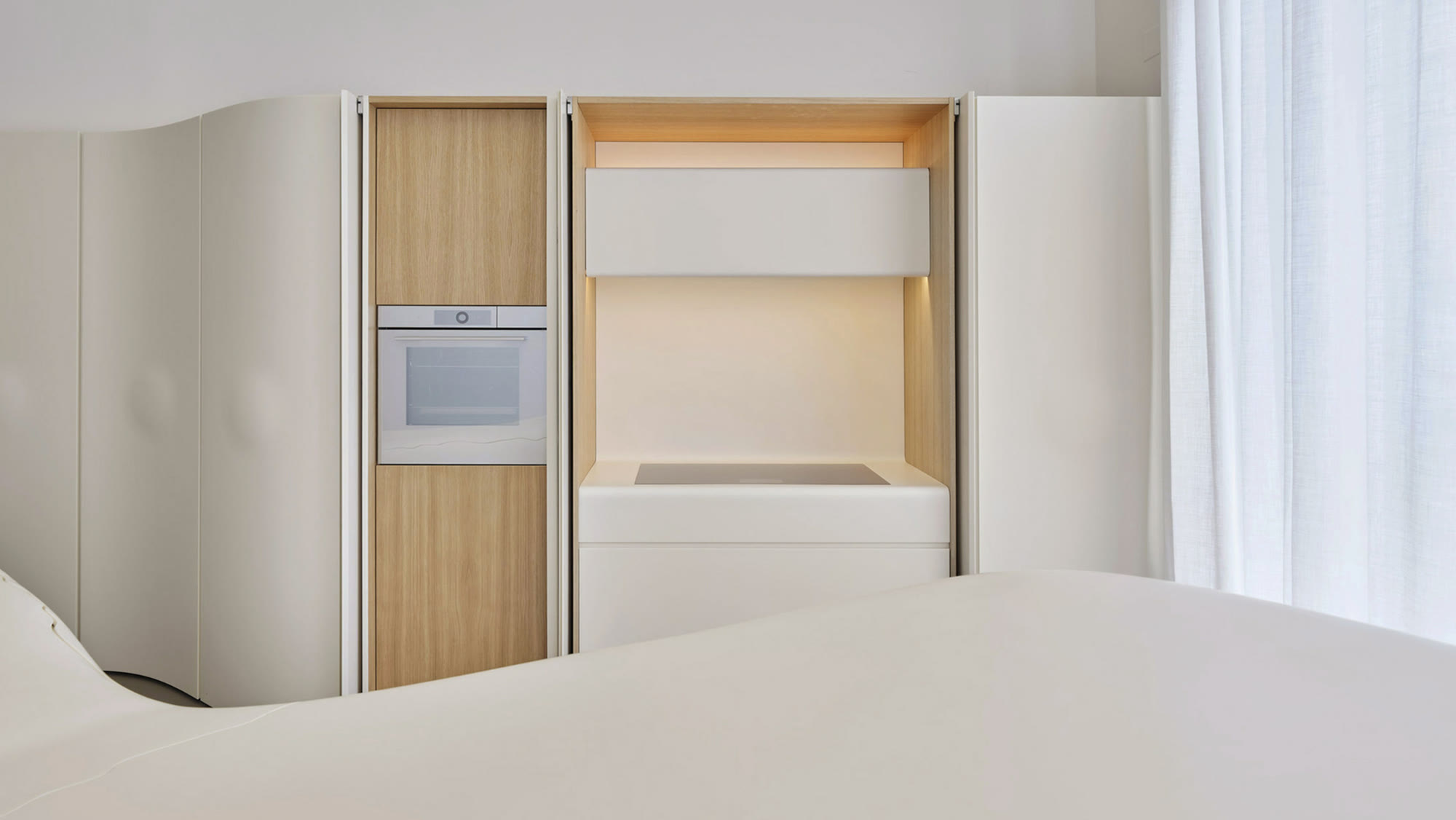 V-ZUG — integrated oven and induction hob within a pale timber kitchen